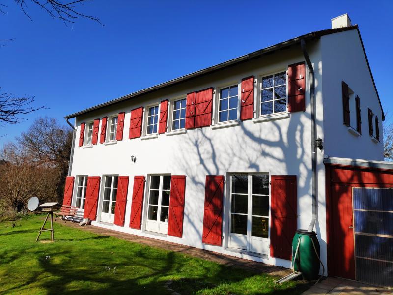 Cette maison séduit par son charme et sa situation au bout d'une impasse avec une vue panoramique incomparable. L'accès avec une porte d'entrée en chêne massif et de vieilles briques d'argile cuites comme revêtement de sol vous mène dans la partie soirée et nuit avec un hall, un WC visiteurs, 3 grandes chambres à coucher, 2 salles de bain dont une en suite, toutes deux avec fenêtre et WC, lavabo et douche, une salle de bain a une baignoire en plus de la douche. A ce niveau se trouve également un espace intermédiaire qui mène par un escalier en bois massif au grenier aménagé d'une surface d'environ 50 m².
Un escalier en pierre arrondi vous mène ensuite à l'étage inférieur, où se trouve la salle de séjour. Il s'agit d'une grande pièce magnifique qui s'intègre discrètement dans les différentes zones. 
Le salon avec un coin télévision et une cheminée à bois confortable, à côté de la salle à manger avec une cuisine ouverte équipée. La buanderie attenante à la cuisine est très pratique et comprend une buanderie, une chaufferie et un espace extérieur couvert. 
On trouve également dans ce grand espace de vie des surfaces utiles qui peuvent être utilisées comme bureau ou comme coin lecture.
Les nombreuses fenêtres au niveau du sol, qui offrent une vue dégagée, donnent une impression d'espace, d'autant plus que l'orientation sud-ouest permet au soleil de pénétrer toute la journée.
À côté du bâtiment principal se trouve une véranda couverte avec un four à barbecue maçonné, qui vous permettra de faire un barbecue agréable même si le temps est changeant.
Il faut en tout cas mentionner le chauffage au sol dans le salon et la chambre à coucher et l'impressionnante hauteur de plafond de 2,83 m dans le salon, qui renforce encore le sentiment d'espace généreux.
Chauffage central au mazout, connexion satellite, compteur à double tarif pour l'électricité. La maison est bien isolée et construite de manière compacte, ce qui témoigne d'une bonne valeur énergétique de classe C. 