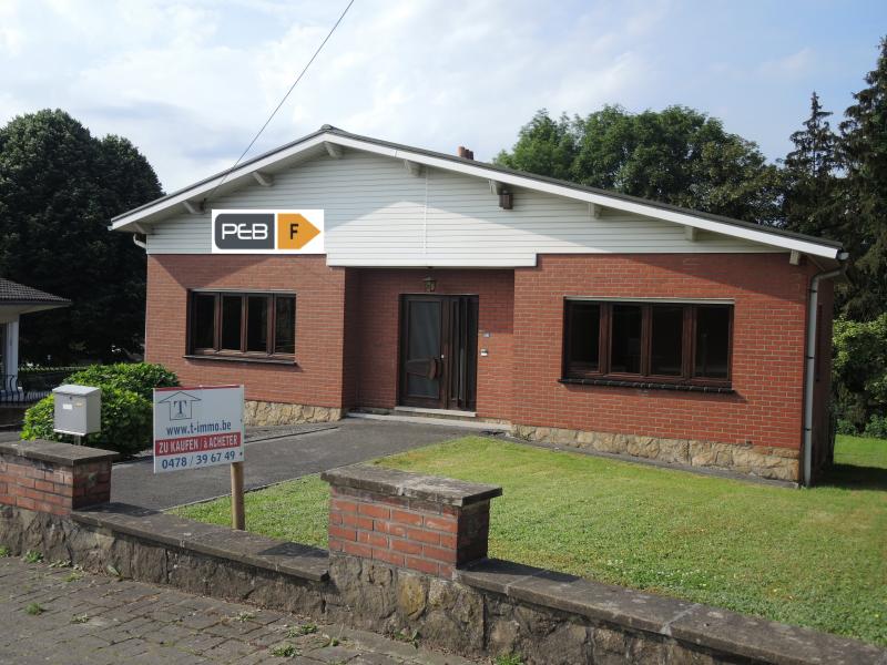 Sehr gepflegter Bungalow, der eine kleine Modernisierung benötigt in einem ruhigen Wohnviertel in Lambermont. Das Haus aus dem Baujahr 1966 besticht durch seine solide Bauweise,  gute Verarbeitung und zahlreichen Annehmlichkeiten zu denen unter anderem die Lage, die Grösse des Grundstückes ca. 1.122 m² und die Nähe zu Verviers zählen.
Die Raumaufteilung ist sehr funktionnel und logisch durchdacht. 
Der grosszügige Eingangsbereich bietet einen direkten Zugang zu allen Räumen einschliesslich Keller und Speicher.
Das Wohn- und Esszimmer erstreckt über die ganze Breite des Hauses und bietet eine wunderschöne Weitsicht sowie die Sicht nach vorne zur Strasse und nach hinten zur Rasenfläche. Dieses Zimmer hat einen direkten Zugang zur Küche und zum grossen Balkon, der sich über eine grossen Teil der Rückfassade mit Süd-Westorientierung erstreckt und die gleiche Weitsicht bietet.
Von der Küche hat man ebenfalls einen direkten Zugang zum Balkon, der auch vom nach hinten gelegenen Schlafzimmer zugänglich ist.
Ein weiteres Zimmer befindet sich im vorderen Bereich des Hauses und kann als zweites Schlafzimmer genutzt werden.
Ein Bad mit Wanne, Waschbecken und WC runden das Raumangebot im Wohnbereich des Hauses ab.
Das Haus ist vollkommen unterkellert mit Heizungs-, Vorrats- , Waschkeller, Dusche und WC, Abstellecke, sowie grosser Garage, die durch ein ferngesteuertes elektrisches Sektionaltor der Marke 