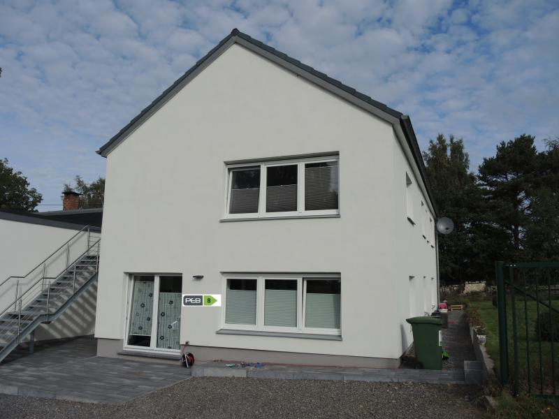 Das neuwertige Appartement befindet sich im E.G. und verfügt über eine Wohnfläche von ca. 95m². Über einen geräumigen Eingangsbereich gelangt man in den lichtdurchfluteten Wohn- Ess-  und Küchenbereich mit einer komplett eingerichteten Einbauküche.
Ein geräumiges Schlafzimmer sowie ein weiteres kleineres Schlaf- oder Bürozimmer mit entsprechenden Fernseh- und Internetanschlüssen ergänzen das Angebot. Das moderne Badezimmer mit italienischer Dusche, Handwaschbecken, Badmobiliar und WC lassen keine Wünsche offen. Ein kleiner Hauswirtschaftsraum, ein Abstellraum sowie ein ebenirdischer Gartenbereich mit Rasenfläche runden das Angebot ab. Das Appartement ist sehr energieeffizient konzipiert mit einer individuellen Gasheizung und weist einen Energieausweis von 163 KWh/m² pro Jahr aus (Label B).
