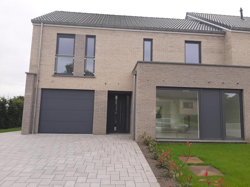 Wunderschönes neues Reihenhaus nach modernsten Standards gebaut.
Es handelt sich um einen Neubau auf einem cirka 400 m² grossen Baugrundstück und ausgestattet mit allen modernen technischen Anforderungen, wie zum Beispiel mechanische Lüftung, Regenwasserzisterne von 10 000 Liter, Gaskondensatortherme, Isolation, usw.
Alle Böden sind komplett gefliest, das Haus hat ebenfalls eine geflieste Terrasse sowie einen mit Bodenklinkern ausgelegten Weg zum Eingang und zur Garage.
Alle Wände sind weiss gestrichen.
Kommen wir nun zur Raumaufteilung, auf dem Erdgeschoss befindet die Eingangdiele mit Gäste-WC und dem Zugang zum wunderbar lichtdurchflutenten Wohn-, Esszimmer mit offener Küche, die einen sehr schönen Blick auf die Terrasse bietet durch die Tatsache, daß zwei Seiten, die die hintere Ecke des Hauses bilden, mit bodenebenen Fenstern ausgestattet sind und Sie so die Mittags- und Abendsonne geniessen können. Der Rest dieses sehr grossen Zimmers (etwa 50 m²) erstreckt sich über die gesamte Länge des Hauses, sodaß  man von der Terrasse einen direkten Blick auf die Strasse haben kann, sofern man dies möchte.
Eine wunderschöne Treppe mit solider Glaswand, führt Sie auf die erste Etage mit Nachtflur mit drei geräumigen Schlafzimmern wovon ein Zimmer noch über enen Ankleideraum verfügt, die wie schon erwähnt, mit Bodenfliesen, die einen Parkettbelag imitieren, ausgelegt sind. Ein weiteres Highlight ist das moderne Bad mit bodenebener italienischer Dusche, WC und Doppelwaschtisch.
Selbstverständlich verfügt dieses Haus ebenfalls über einen nach Süden ausgerichteten Balkon.
Ein grosser Speicher eignet sich hervorragend dazu, nicht oft benötigte Utensilien zu lagern.
Das Haus verfügt natürlich über eine mit einem elektrischen Sektionaltor geschlossene Garage mit Zugang zum Garten und einen  Hauswirtschaftsraum mit Waschmaschinenanschluss. Dieser Raum befindet sich zwischen Küche und Garage, sodaß dort ebenfalls alle nötigen Vorräte zwischengelagert werden können. Sehr schöne Lage am Stadtrand von Welkenraedt und fantastischer Weitblick.