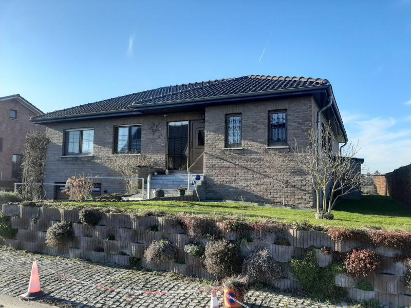 Dieses Haus befindet sich in einer Sackgasse, die absolute Ruhe garantiert. Ein Einfamilienhaus in einwandfreiem Zustand und sehr gepflegt. Dieser Bungalow wurde 1990 erbaut und verfügt über drei Schlafzimmer. Umgeben von einem hübschen Garten mit Südwestausrichtung erstreckt sich das Grundstück über 621 m².
Die Wohnfläche beträgt +/- 115 m² und setzt sich wie folgt zusammen: Eingangsdiele mit Gäste-WC, großes Wohnzimmer, in dem sich ein offener Kamin befindet, der nicht genutzt wird, aber mit der Möglichkeit, ihn zu aktivieren. Ausserdem ein  direkter Zugang zur Aussenterrasse und zum Garten mit freiem Blick.  Eine komplett ausgestattete Einbauküche ist vom Wohnzimmer und Eingangsbereich zugänglich. Darüber hinaus gibt es drei Schlafzimmer, ein Badezimmer mit Dusche, Doppelhandwaschbecken und WC. Das ganze Haus ist unterkellert mit einer sehr großen Garage, die viel Platz bietet, einer Waschküche, ein Abstellraum, ein Keller sowie ein Hauswirtschaftsraum mit Spüle und der Gaszentralheizung.
Hervorragende Lage in einer Sackgasse, Garten rundum, Fliesenböden, Fensterrolläden (teilweise elektrisch), ein Wohnhaus in ausgezeichnetem Zustand und umgeben von einer malerischen Landschaft.
Alle Annehmlichkeiten wie Geschäfte, Schulen, Bus und Bahnanschluss, Autobahnauffahrt in unmittelbarer Umgebung.
